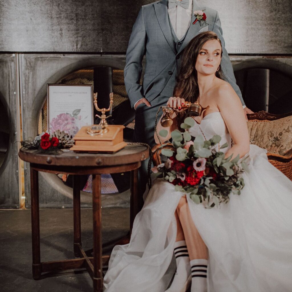 Braut hält den Hörer eines Vintage-Telefons bei einer Hochzeit im Industrial-Stil