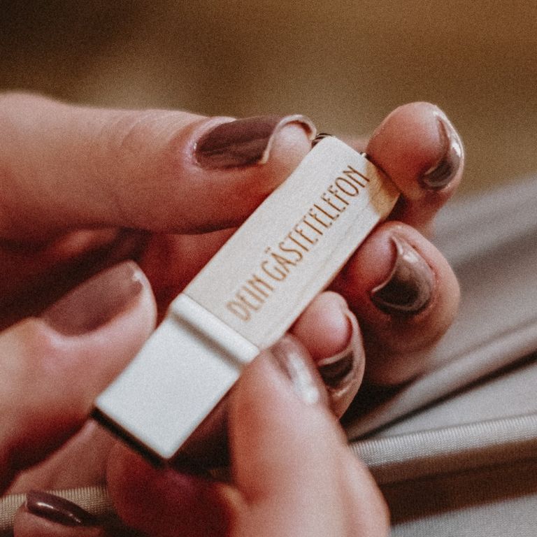 Gästetelefon USB Stick gehalten von Frauenhänden. Lackierte Fingernägel. USB Stick Holz mit Gravur Dein Gästetelefon. audiogästebuch mieten günstig sicher schneller versand videofon video-gaestebuch videogastebuch video-gästebuch videogästebuch videogaestebuch video-gaestebuch deinvideofon gästebuchvideo
